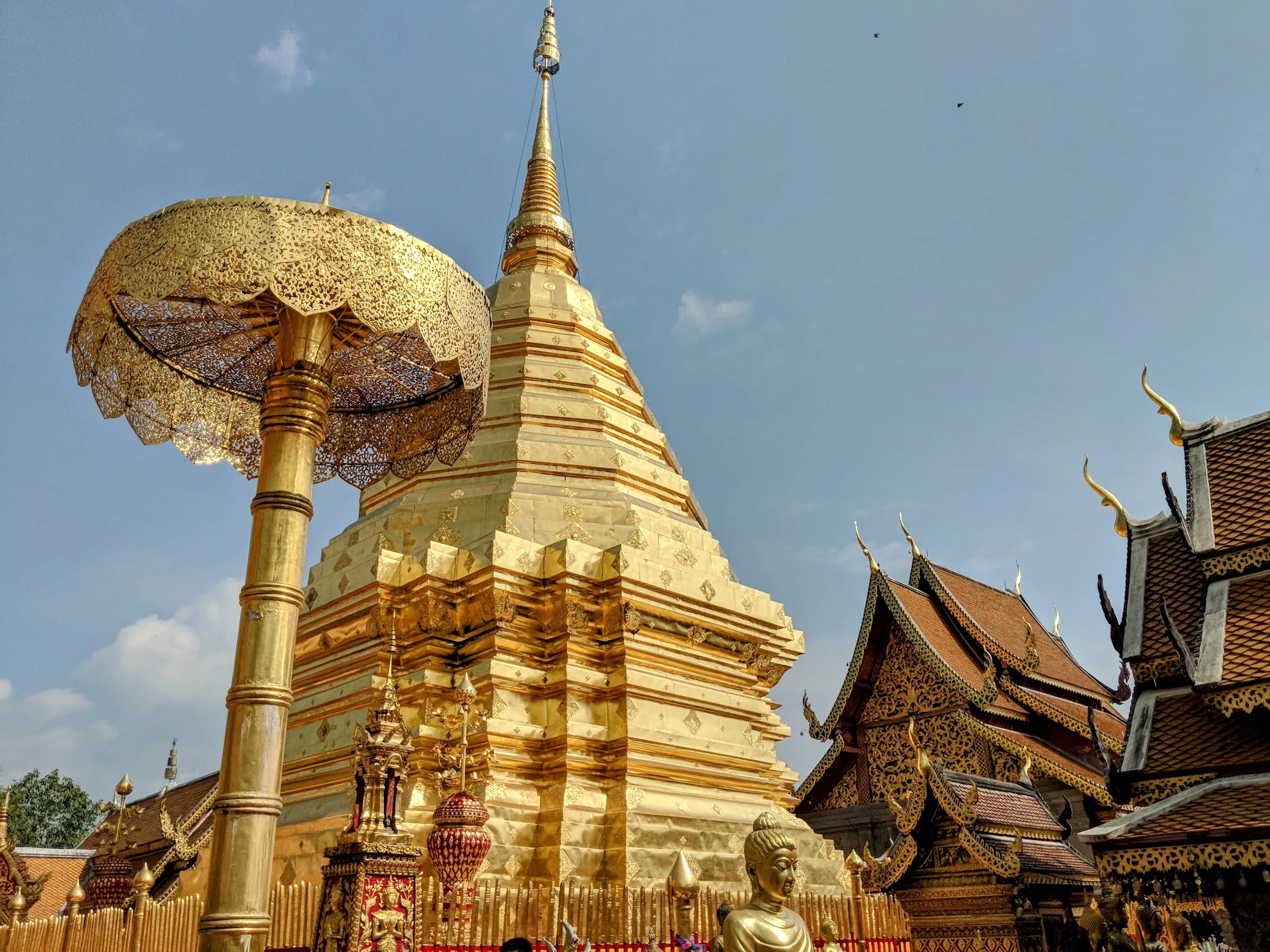 The golden chedi and pierced gold umbrella at Wat Phra That Doi Suthep, with the Lanna viharn roof behind
