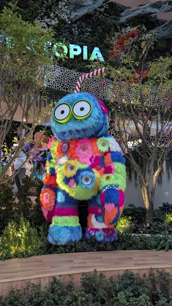A colorful furry art-toy monster sculpture in a mall garden installation, Bangkok