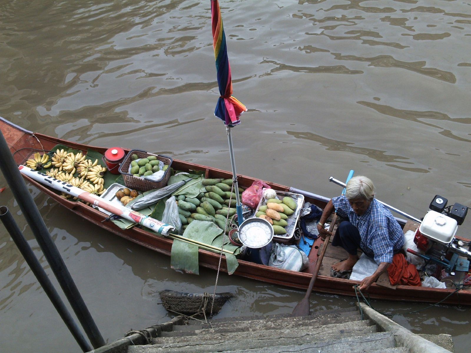 A floating market vendor’s boat filled with fresh tropical fruit near Bangkok