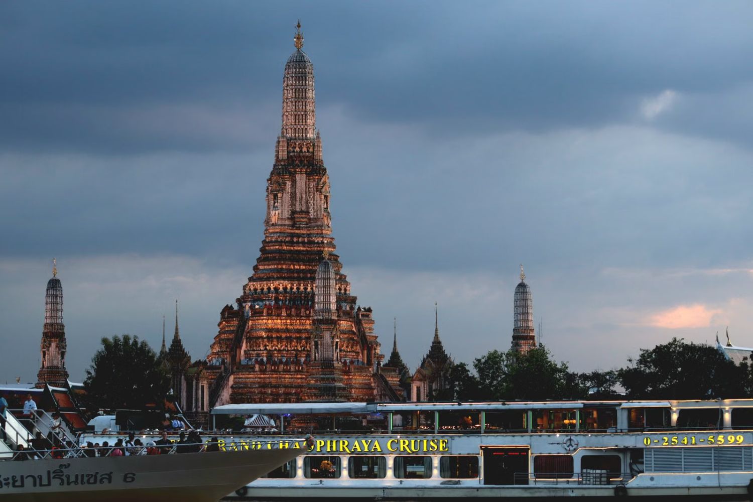 Longtail boats moored below the spires of Wat Arun on the Chao Phraya River