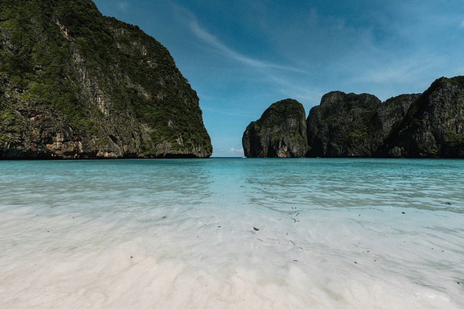 A turquoise bay ringed by limestone cliffs on the Andaman coast