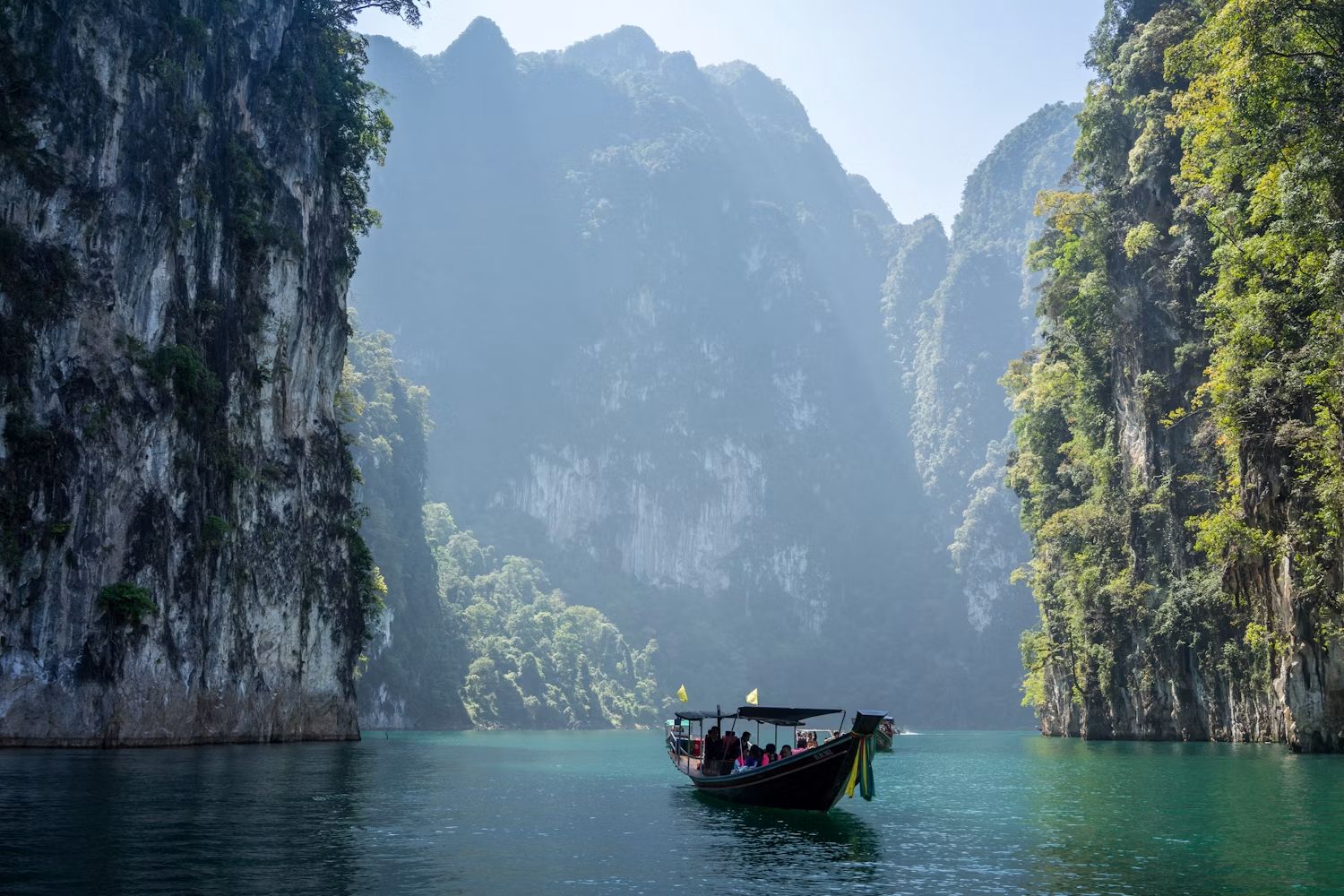 A longtail boat between the limestone karsts of Cheow Lan Lake in Khao Sok National Park