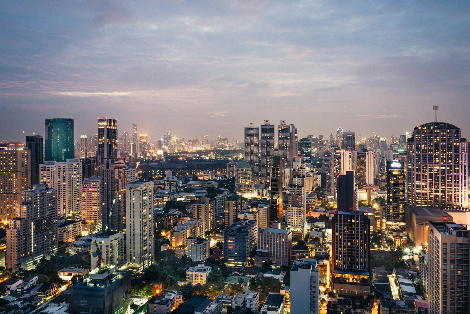 Bangkok skyline silhouetted at sunset from a rooftop