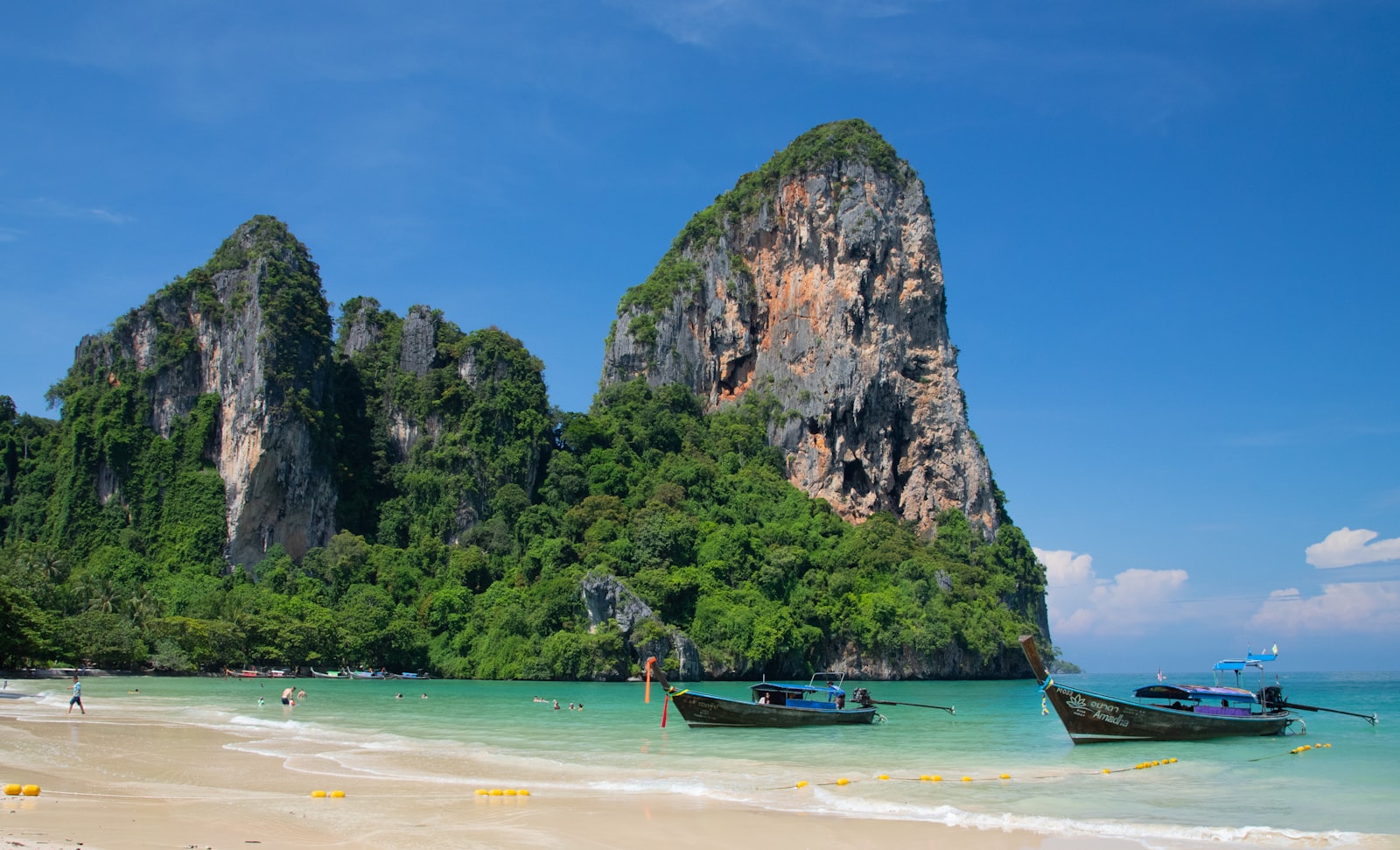 Railay’s limestone cliffs meeting white sand and longtail boats, Krabi