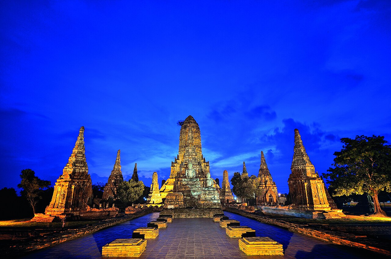 Wide shot: brick prang towers of Wat Chaiwatthanaram at golden hour
