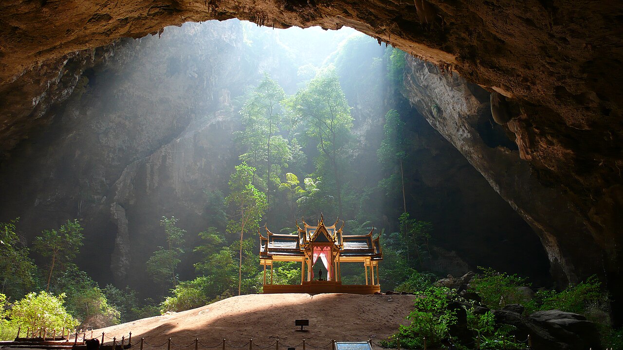 Wide shot: sunbeam falling through the roof of Phraya Nakhon Cave
